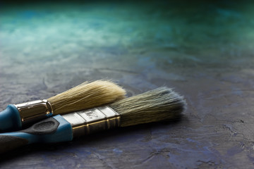 Two brushes on a blue background. Artist's working tools for creating a fashionable interior....