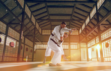 Fototapeta premium Karate fighters on tatami at sunrise. Japanese hall.