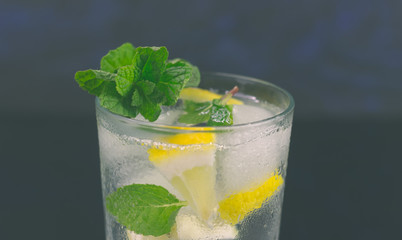 Lemonade with fresh lemon and mint leaves on copy space background