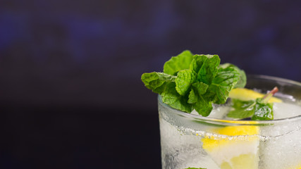Lemonade with fresh lemon and mint leaves on copy space background
