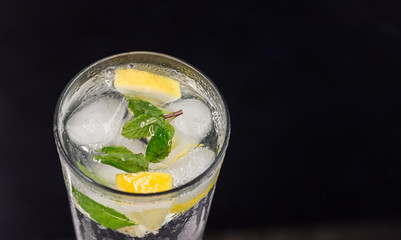 Lemonade with fresh lemon and mint leaves on copy space background