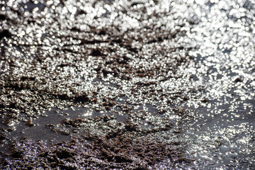 Wet mud with glare on the road