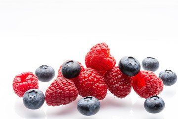 Ripe wild berries on a white background. Garden raspberries. Ripe blueberries. White background. Red. Blue. Isolated.