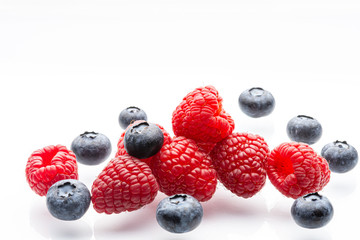 Ripe wild berries on a white background. Garden raspberries. Ripe blueberries. White background. Red. Blue. Isolated.