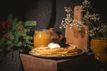 A stack of pancakes with sour cream and jam