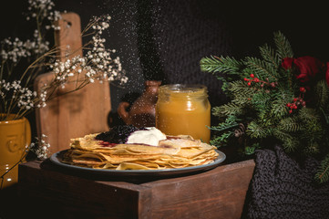 A stack of pancakes with sour cream and jam