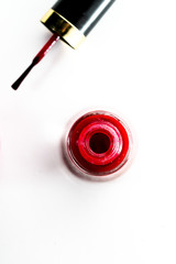Opened bottle of red nail polish on white background