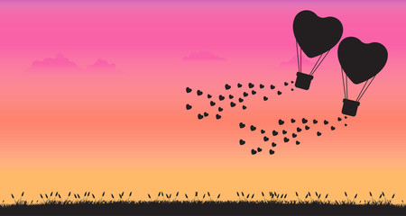 Silhouette balloon heart shape flying on sunset background