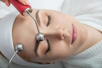 Woman getting lifting therapy massage in a beauty SPA salon.