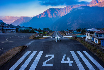 Lukla, NEPAL - December 2, 2019: Lukla airport. In the frame of the airport runway and taking off...