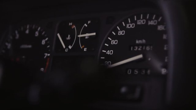 JDM car speedometer closeup with moving light in the dark