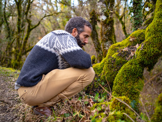 A Man Observing Something In The Moss