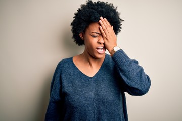 Obraz na płótnie Canvas Young beautiful African American afro woman with curly hair wearing casual sweater Yawning tired covering half face, eye and mouth with hand. Face hurts in pain.