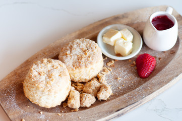 Fresh scones butter and strawberry jam serve on wooden tray, food stylish.