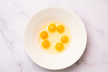 raw quail eggs on a white plate