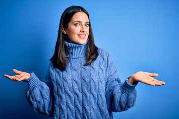 Young brunette woman with blue eyes wearing casual turtleneck sweater smiling showing both hands open palms, presenting and advertising comparison and balance