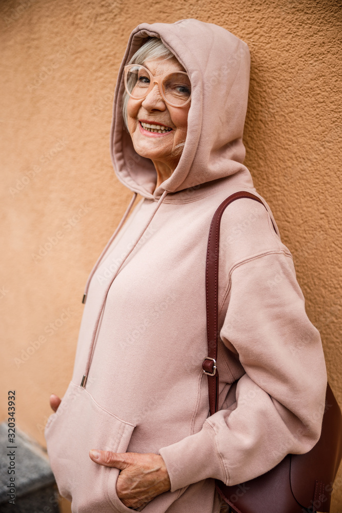 Poster smiling old lady in hoody stock photo