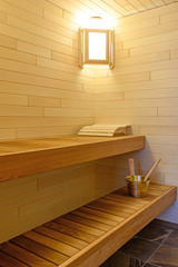 Interior of a sauna with shelves and a bench made of wood
