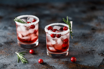 Cranberry cocktail with ice. Christmas cranberry beverage in glasses decorated with sugar and rosemary