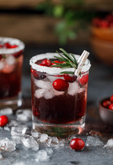 Cranberry cocktail with ice. Christmas cranberry beverage in glasses decorated with sugar and rosemary