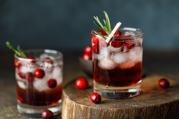 Cranberry cocktail with ice. Christmas cranberry beverage in glasses decorated with sugar and rosemary