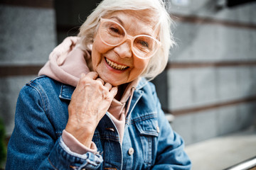Smiling aged woman in jeans jacket stock photo - obrazy, fototapety, plakaty