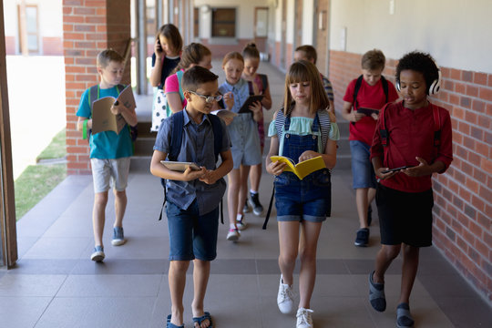 Group of school pupils walking in an outdoor corridor at elementary school