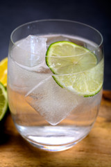  Cold drinking mineral water served in glass with ice cubes and green lime