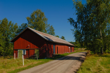 Fototapeta na wymiar red barn by a country gravel road