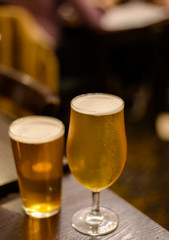 Misty glasses with two pints of cold Scotch ale, pale ale, lager draft beer in English pub