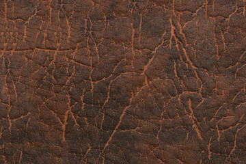 Brown faux leather. Textured surface with a pattern.