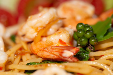 Spicy shrimp spaghetti fresh pepper close up with tomato slice, cucumber slice, salad in warm hot high light stock photo