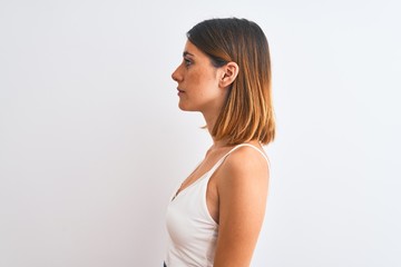 Beautiful redhead woman wearing casual white t-shirt over isolated background looking to side,...