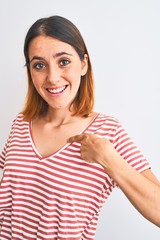 Beautiful redhead woman wearing casual striped red t-shirt over isolated background with surprise face pointing finger to himself