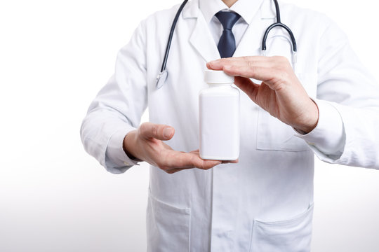 Cropped photo of medical employee demonstrating a bottle of drugs he is holding with both hands isolated white background copyspace cropped