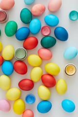 Top view of multi colored Easter eggs arraigned in minimal composition on white background, copy space