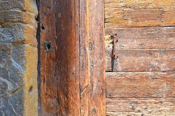 part of old wooden doors with rough surface and metal handle