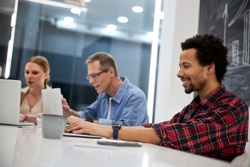 Smiling afro american man working with colleagues in office