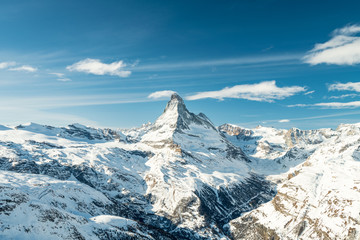Scenic view on snowy Matterhorn (Cervin, Cervino) peak in sunny day with blue sky, pine trees,...