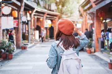 Young woman traveler walking in the shopping street, Travel lifestyle concept