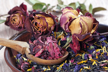 dry hibiscus petals in a wooden spoon. blended black tea with flower petals, hibiscus and dry roses