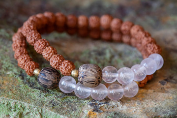 mineral stone beads and natural rudraksha seed beads bracelet on rocky background