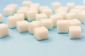 Sugar addiction, insulin resistance, unhealthy diet, sugar cubes on blue background, diabetes protection concept, top view.