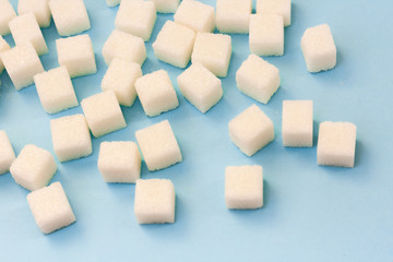 Sugar addiction, insulin resistance, unhealthy diet, sugar cubes on blue background, diabetes protection concept, top view.