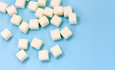Sugar addiction, insulin resistance, unhealthy diet, sugar cubes on blue background, diabetes protection concept, top view.