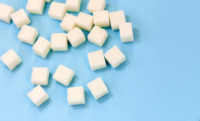 Sugar addiction, insulin resistance, unhealthy diet, sugar cubes on blue background, diabetes...