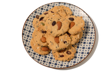 Multigrain cookies (almond, cranberries, cashew nut, pumpkin and sasame seeds) on five-pointed flower pattern, isolated white background, top view.