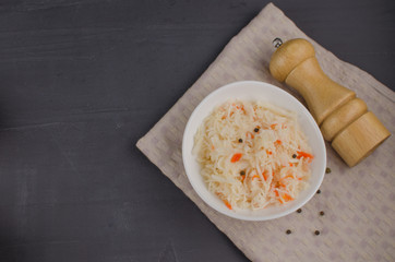 sauerkraut and carrots in a plate. horizontal view from above, rustic style. Fermented food. Copy space.