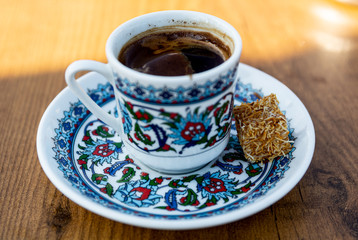 Colorful texture cup of Turkish coffee on the wooden table, a coffee shot.