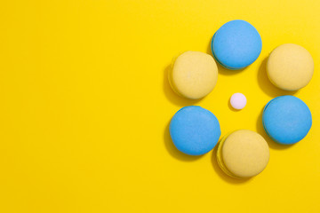 macaroni cookies laid out in a circle on a bright yellow background with copy space